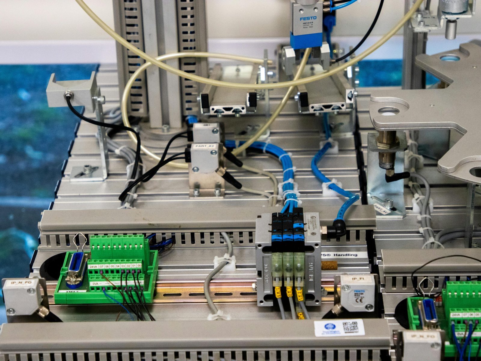 Close-up of industrial equipment showcasing electronic wiring and sensors in a manufacturing setup.